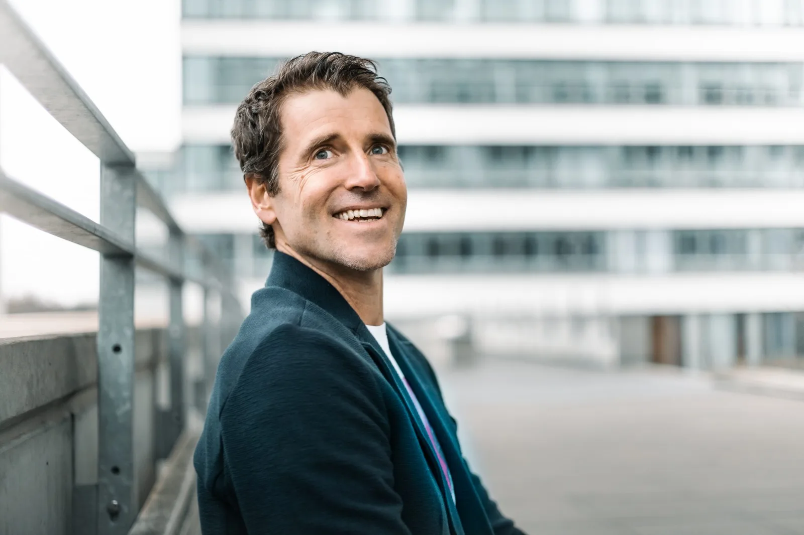 Portrait von Claus-Stefan Duffner auf moderner Dachterrasse mit Bürogebäuden im Hintergrund