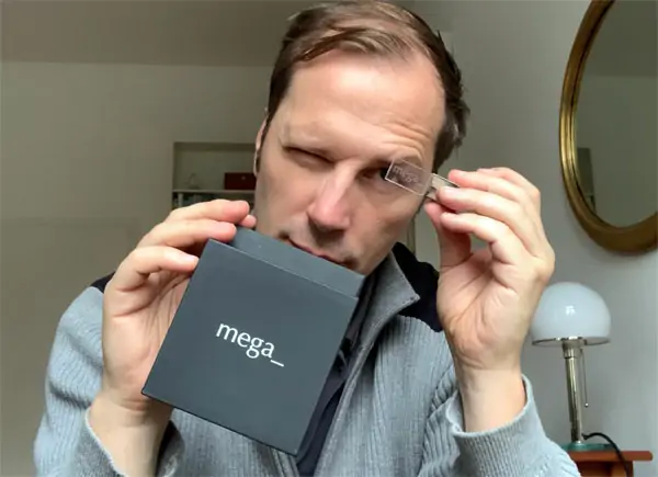 Mann hält schwarze Mega Stick Box in den Händen und schaut nach unten