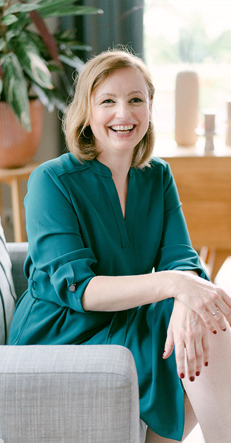 Marike Frick, blonde Frau in türkisem Blazer, lächelnd, Porträt im modernen Büro