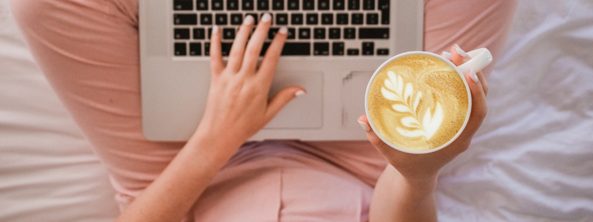 Mein Therapie Tagebuch – Bundle für Psychologie 3 Frau mit rosa Oberteil arbeitet am Laptop und hält Kaffee mit Latte-Art, Vogelperspektive