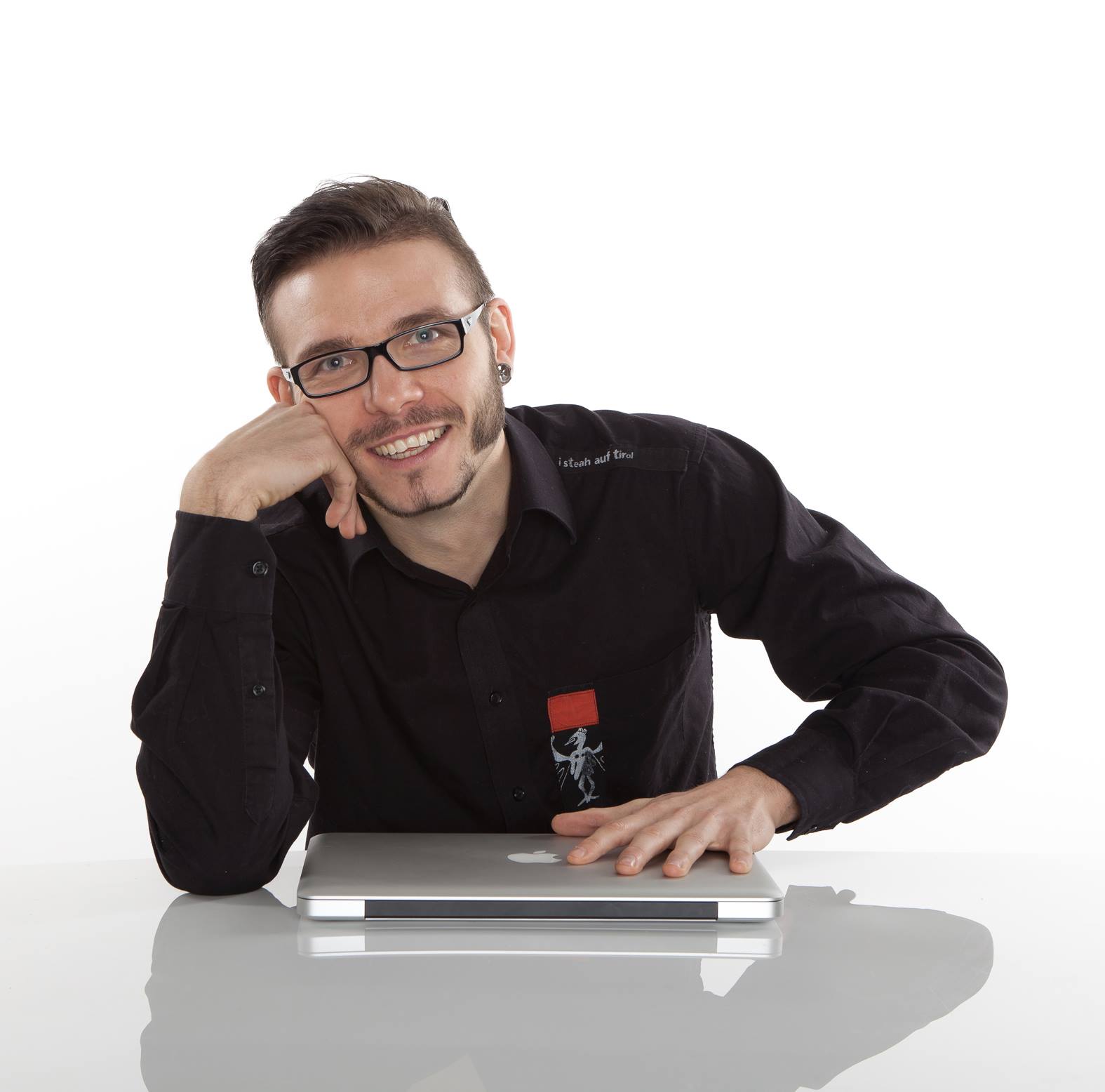 Christoph Steinlechner Portrait, junger Mann mit Brille an Laptop sitzend