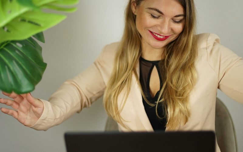 Meta Werbeanzeigen Teil 2 – Live-Workshop zu Facebook-Ads 4 Frau mit beigem Blazer und schwarzem Top arbeitet am Laptop, grüne Pflanze im Hintergrund