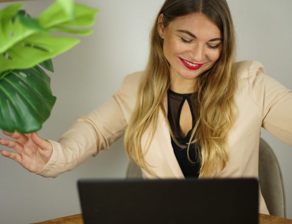 Meta Werbeanzeigen Teil 2 – Live-Workshop zu Facebook-Ads 6 Frau mit beigem Blazer und schwarzem Top arbeitet am Laptop, grüne Pflanze sichtbar