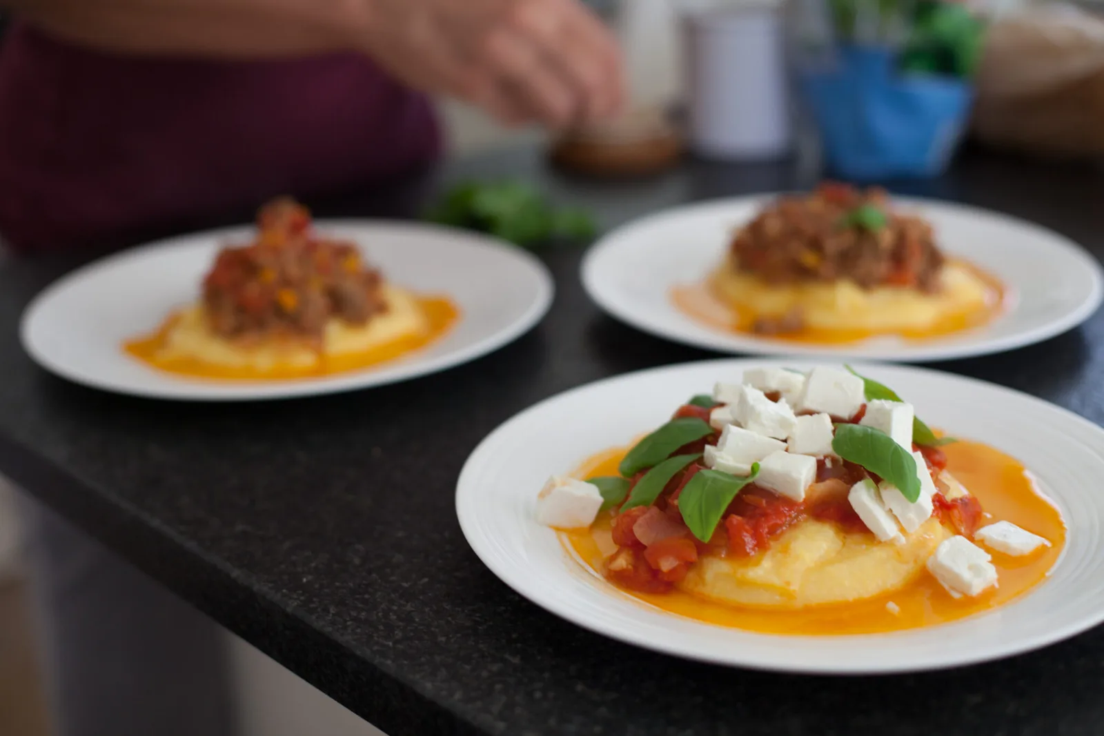 Drei plattierte Gourmet-Gericht mit Sauce, Gemüse und Käse auf weißen Tellern
