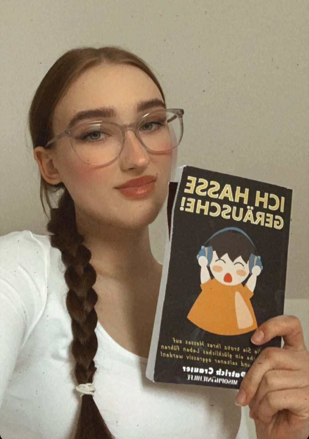 Leserin mit Brille hält Buch Ich hasse Geräusche bei Instagram