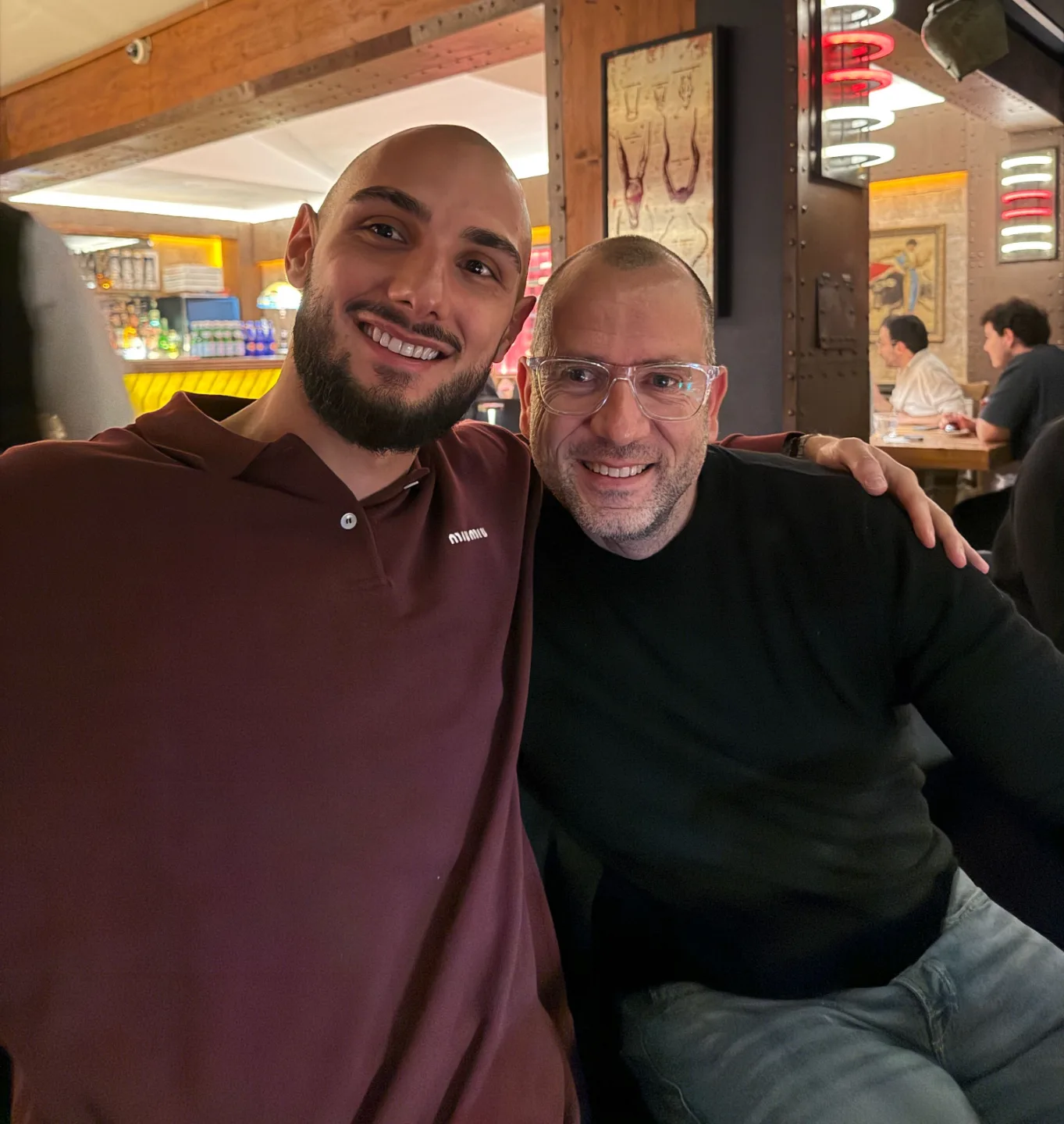 Christian Pflug mit jungem Mann in Restaurant, freundschaftliches Foto