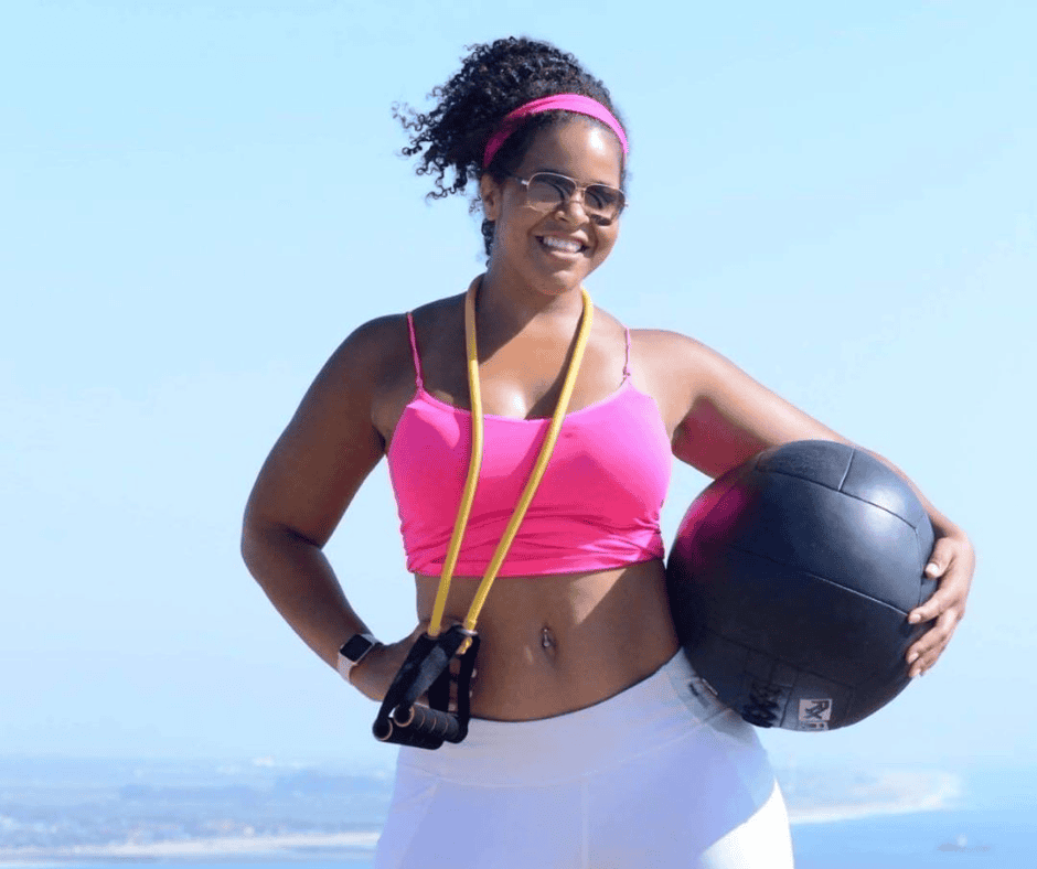 Afroamerikanische Frau in pinkem Sports-Top mit Medicine Ball und Springseil