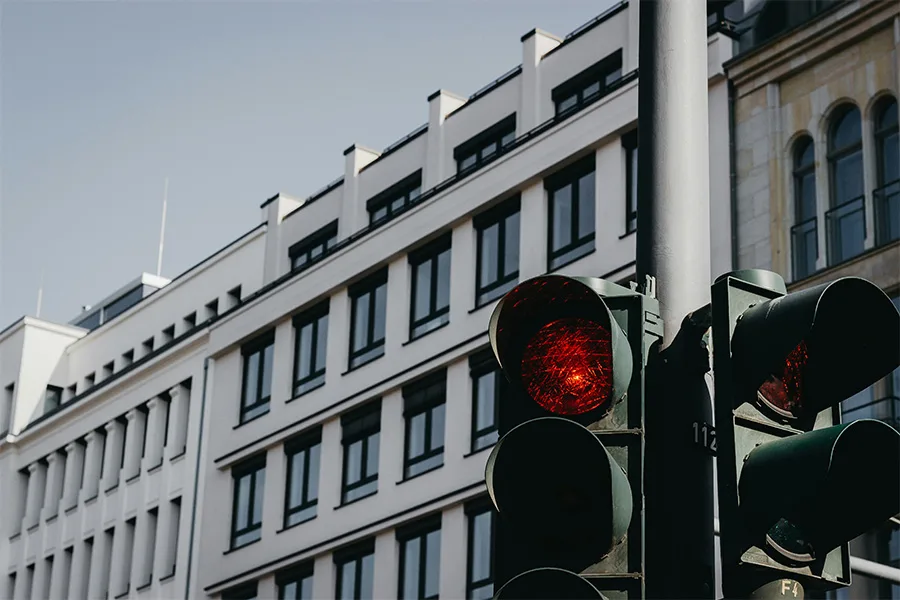 Rotes Ampellicht vor modernem Bürogebäude in Augsburg zur Illustration von Verkehrsthemen