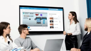 Gruppe von vier Personen vor Bildschirm mit IT-Sicherheits-Lernvideo zu MAC-Adressen und Netzwerken