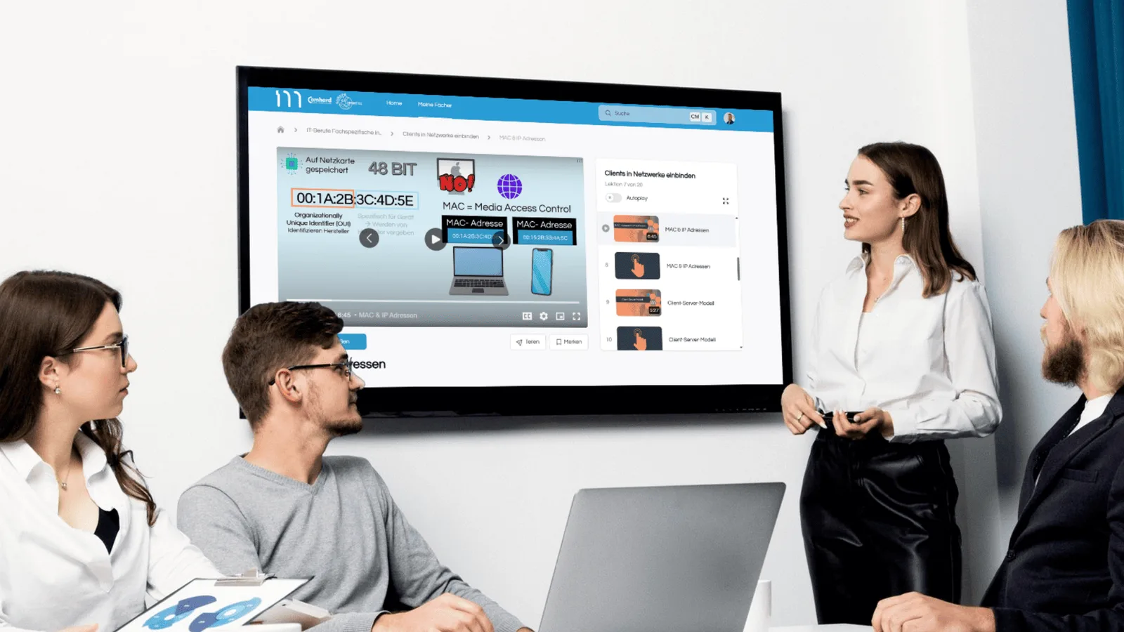 MyDigiAcademy – Prüfungstrainer-Lernapp von Florian Honold 4 Vier Personen in professioneller Umgebung schauen auf großen Bildschirm mit MAC-Adressen-Lernvideo und 48-Bit-Konzept