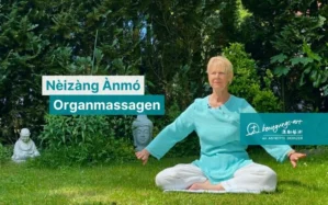 Annette Deinzer im türkisem Qi-Gong-Anzug sitzt meditativ im Garten, Nèizàng Ànmó Organmassagen Hero