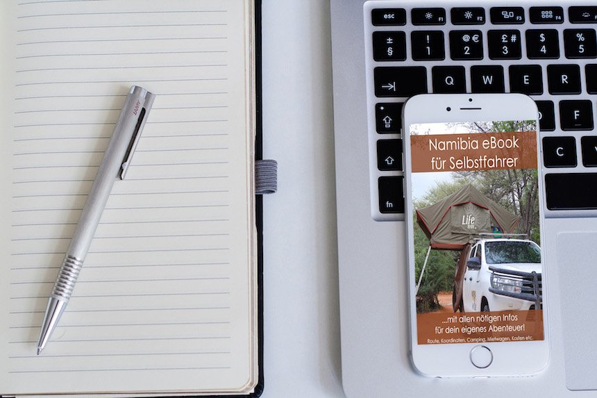Namibia eBook auf Smartphone neben Laptop und Notizbuch auf Holztisch