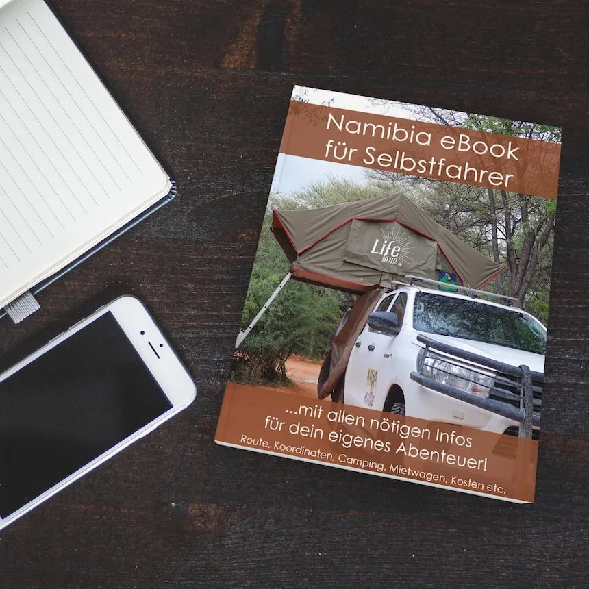 Namibia eBook auf dunklem Holz neben Notizbuch und Smartphone