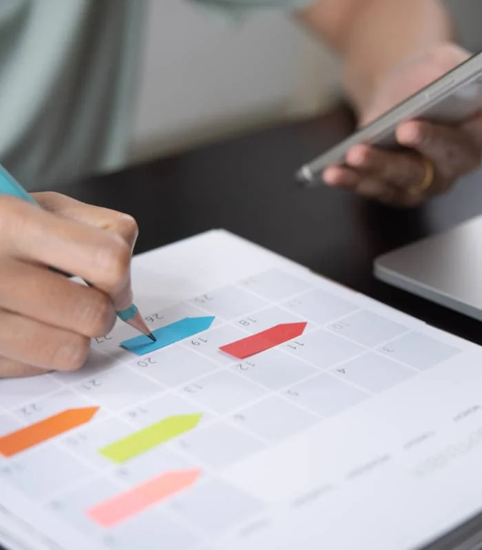 Foto: Zwei Personen analysieren farbliche Balkendiagramme auf Papier mit Stift und Tablet
