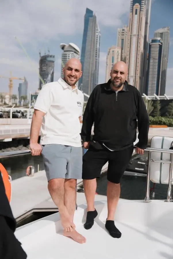 Zwei Männer mit Lanyard beim Mastermind in Dubai, Skyline im Hintergrund