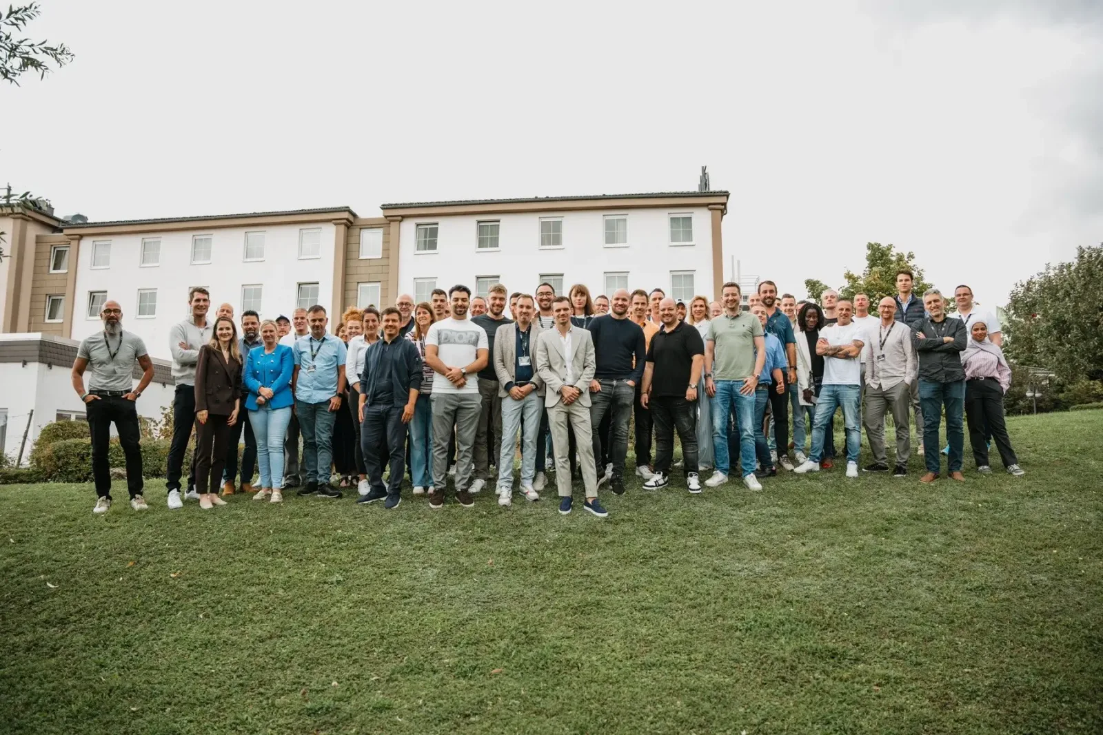Über 40 Mitglieder des No Limit Club stehen vor historischem Gebäude auf Rasenfläche