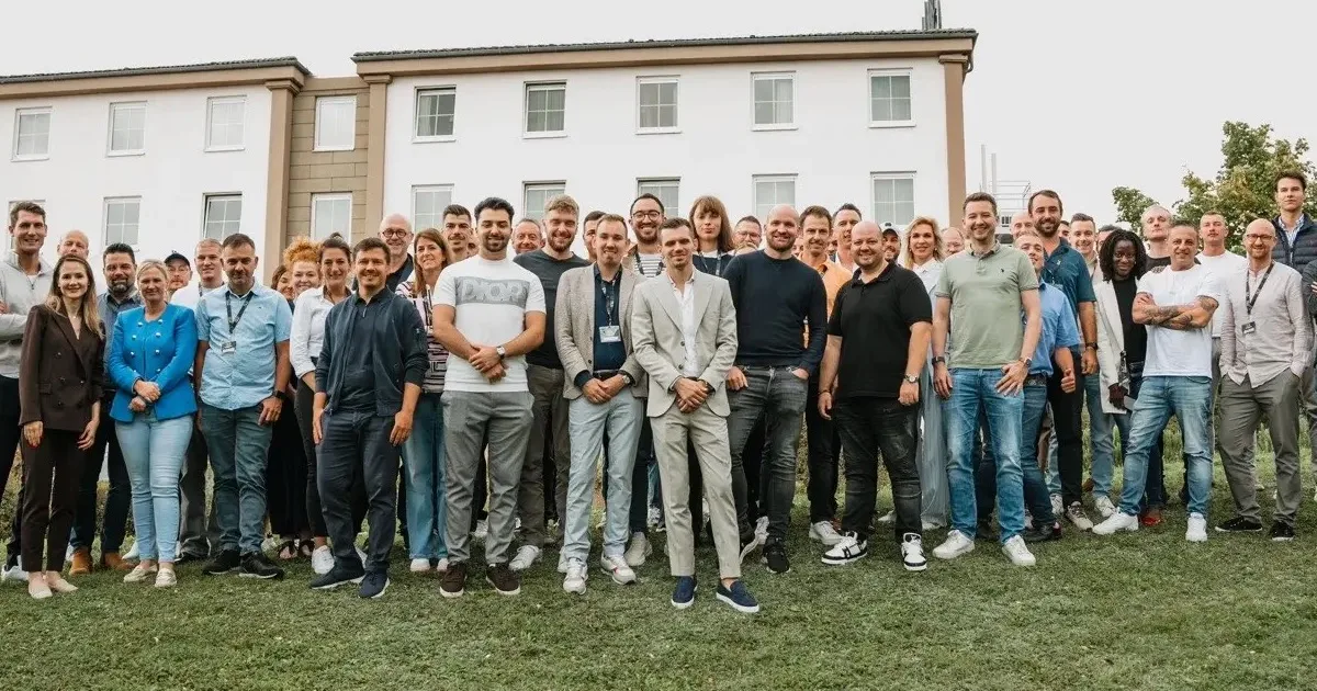 Große Gruppe von Immobilien-Investoren vor klassischem Herrenhaus, No Limit Club Community
