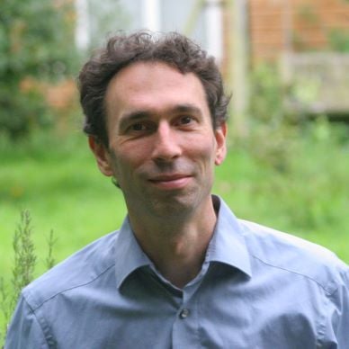 OCTAVIA – Klangreise mit 432-Hz-Musik von Dieter Broers 3 Porträt von Simon Fox, junger Mann mit lockigem dunklem Haar vor grünem Garten-Hintergrund