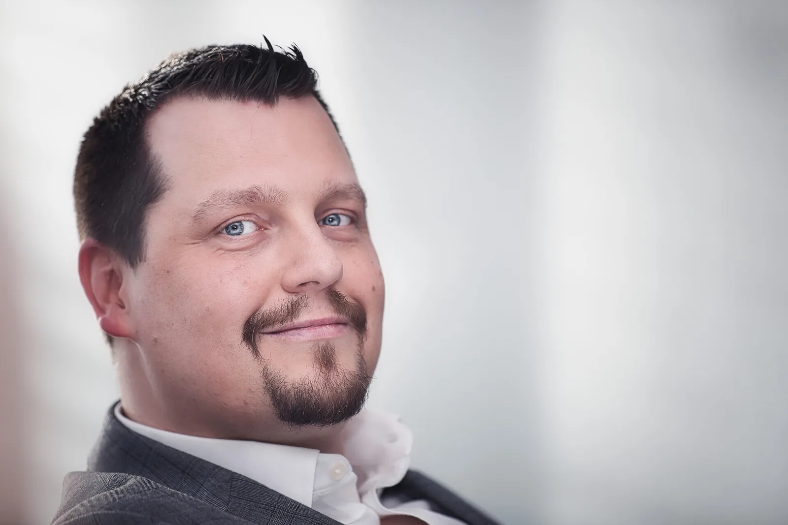 Seitenprofil Martin Jäger mit Bart und Anzug vor hellem Hintergrund