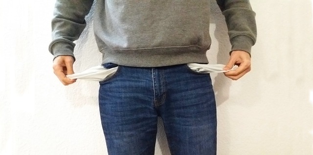 Person ohne Geld mit leeren Taschen, Geldmangel-Symbol