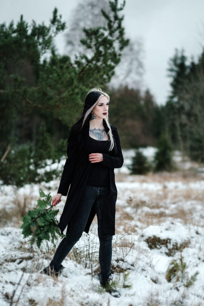 Porträt einer Frau mit tattouiertem Nacken in schwarzem Blazer im Schnee mit Radial-Blur-Effekt