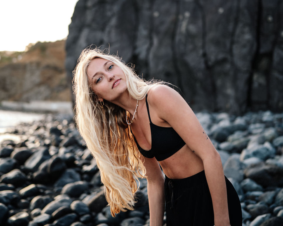 Blonde Frau an Steinküste – Nachher-Bild mit ONE Preset