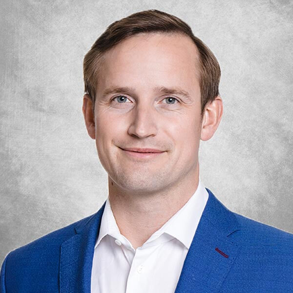 Mann mit braunem Haar in blauem Blazer und weißem Hemd
