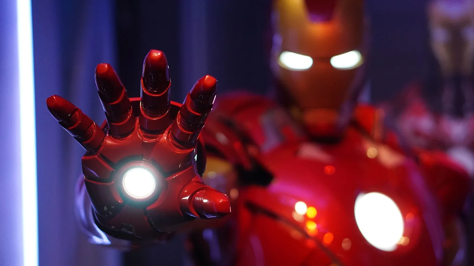 Iron Man Hand mit leuchtend weißem Arc Reaktor gegen dunklen Hintergrund