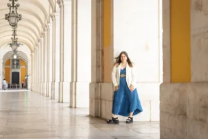 Carolin Mallmann in eleganter Kleidung in einer klassischen Säulenhalle mit Bögen
