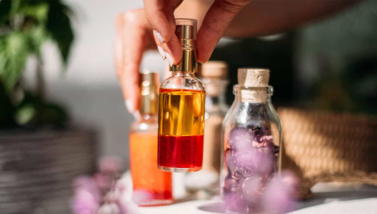 Online Heilpflanzen Akademie – Videokurs zur Wildkräuterkunde 14 Hand hält Flasche mit rotem Öl-Extrakt, verschiedene Naturkosmetik Öle und Tinkturen