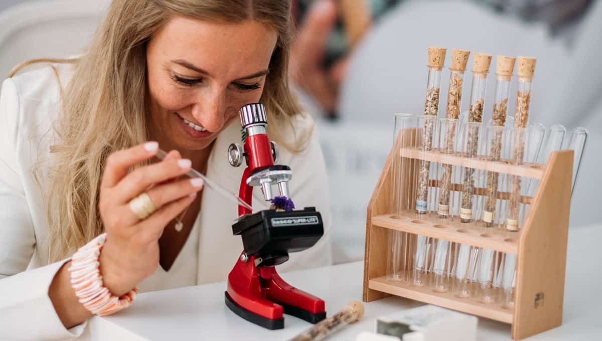 Online Heilpflanzen Akademie – Videokurs zur Wildkräuterkunde 5 Dr. Patricia Purker untersucht Heilpflanzen unter rotem Mikroskop mit Extraktions-Reagenzgläser