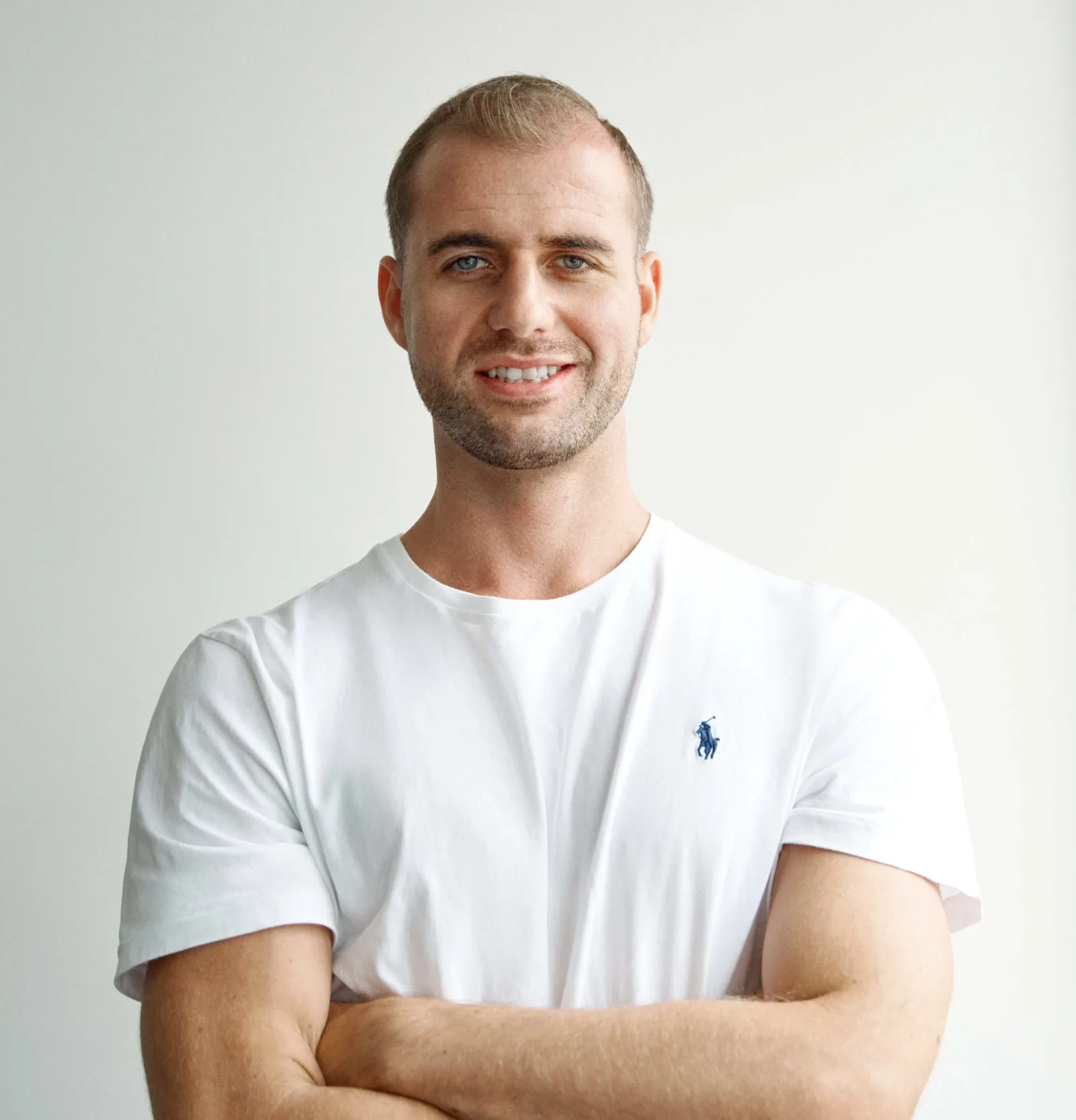 Porträt-Foto von Michael Rolle in weißem Poloshirt vor neutral grauem Hintergrund