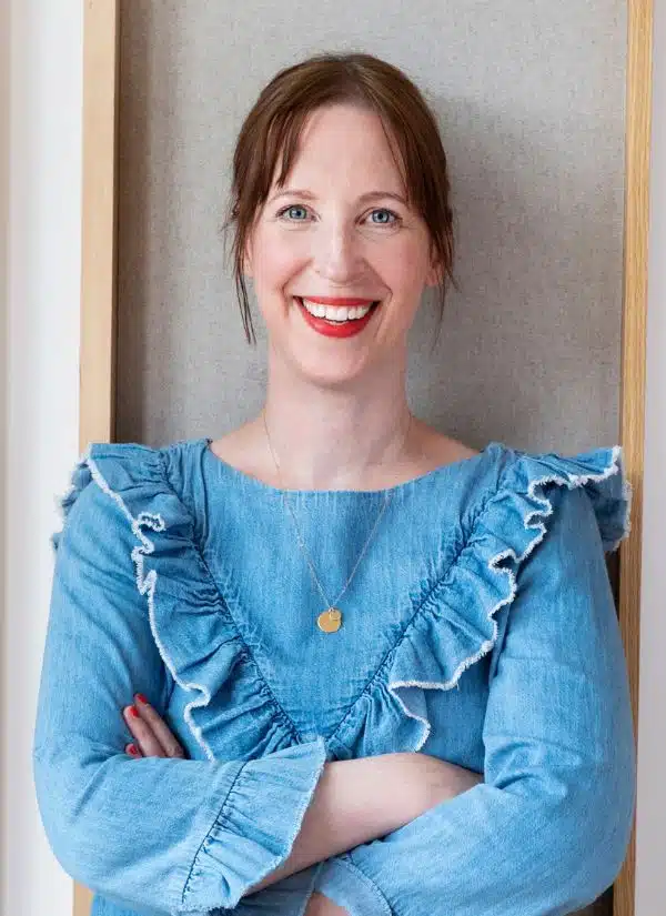 Steffi Mixa, Frau mit Hochsteckfrisur, rote Lippen, Denim-Oberteil mit Volants