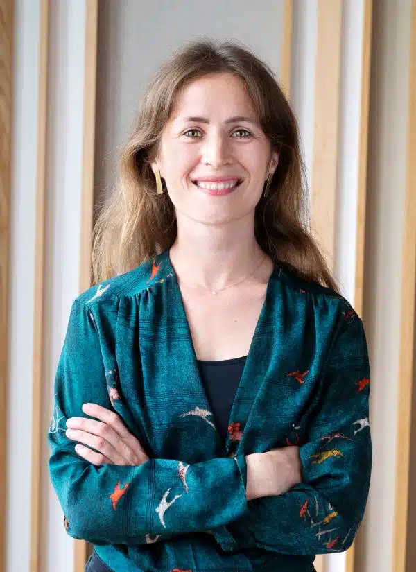 Leonie Schürtz mit braunen Haaren und türkisem Blazer mit Muster