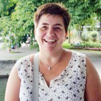 Susanne Reber, Frau mit braunem Haar, Halskette, gepunktetes Oberteil