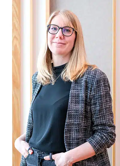 Helen Scheuning, Frau mit blondem Haar, Brille, Blazer, dunkles Oberteil