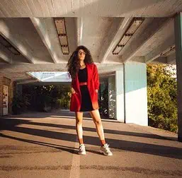 Frau in rotem Blazer unter Betonviadukt