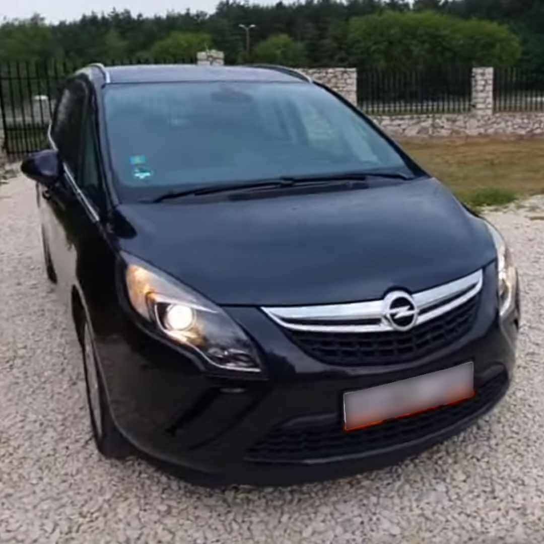 Opel Zafira C Tourer schwarzer Kleinbus, Frontansicht, parkend auf Kiesplatz