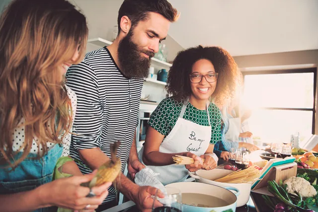 Drei Freunde internationaler Herkunft kochen zusammen in der Küche
