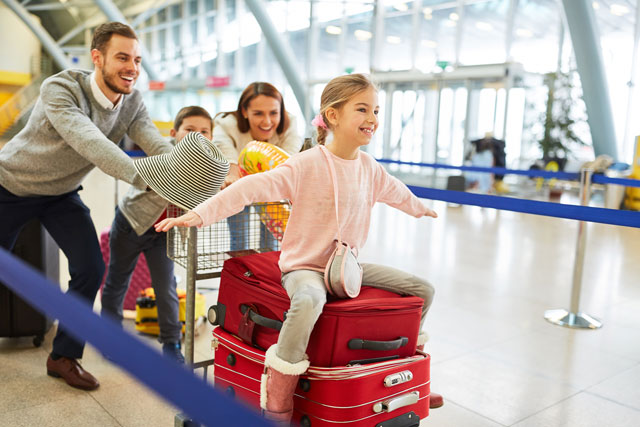 Original Birkenbihl-Sprachkurs Englisch für Urlaub & Reise 8 Familie am Flughafen, kleines Mädchen sitzt auf rotem Koffer mit ausgestreckten Armen
