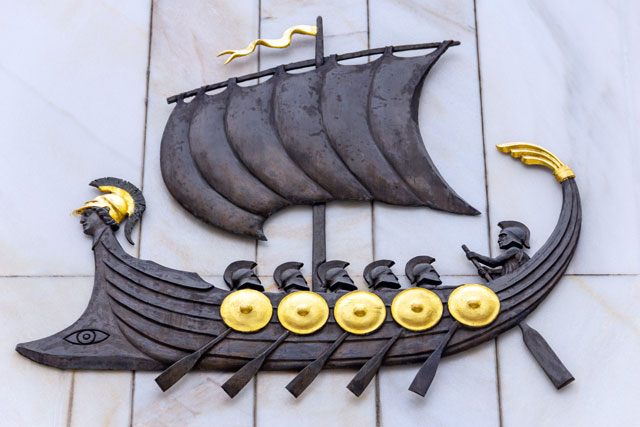 Griechisches Schiff Argo aus Stein mit Drachenköpfen und goldenen Verzierungen an Bug und Heck