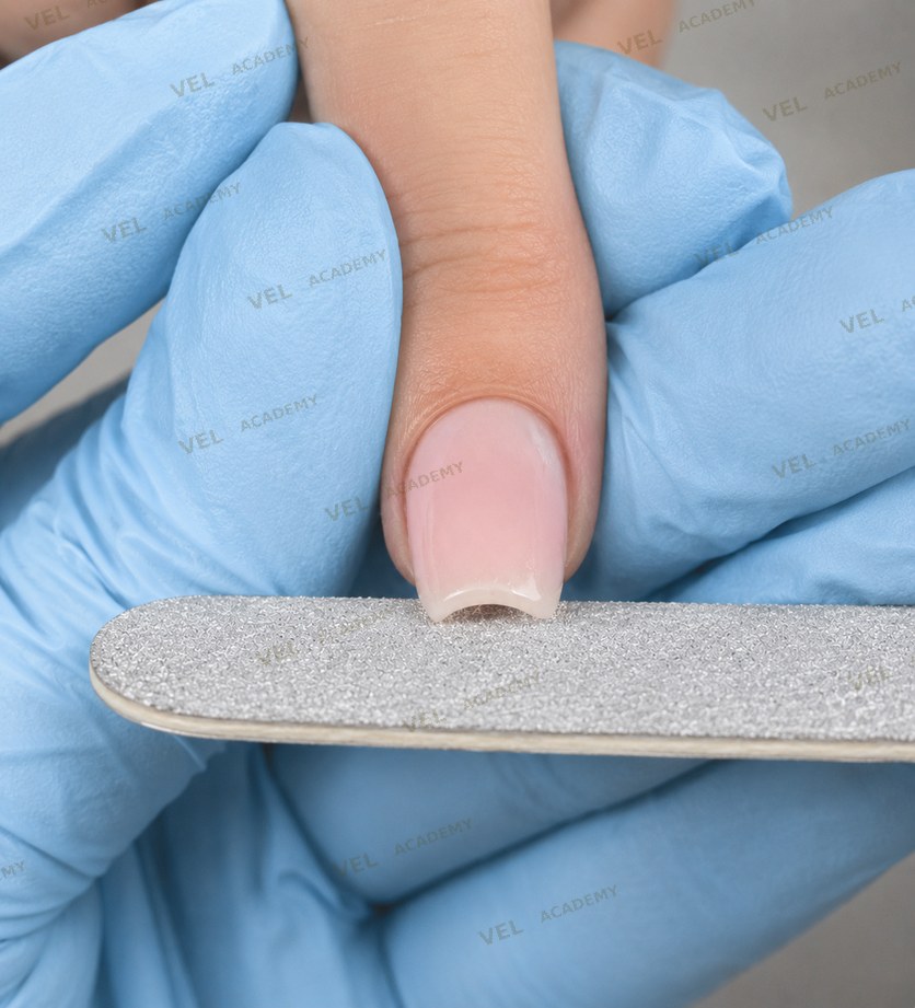 Detailaufnahme beim Feilen eines ovalen Nagels mit Glasfeile und professioneller Technik