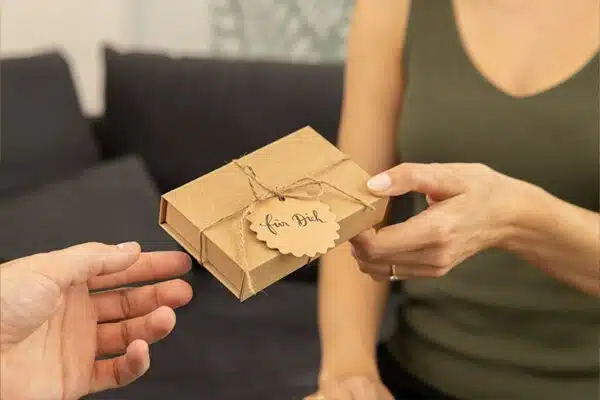 Hände beim Austausch von Magoody Geschenkbox Paarmassage Gutschein