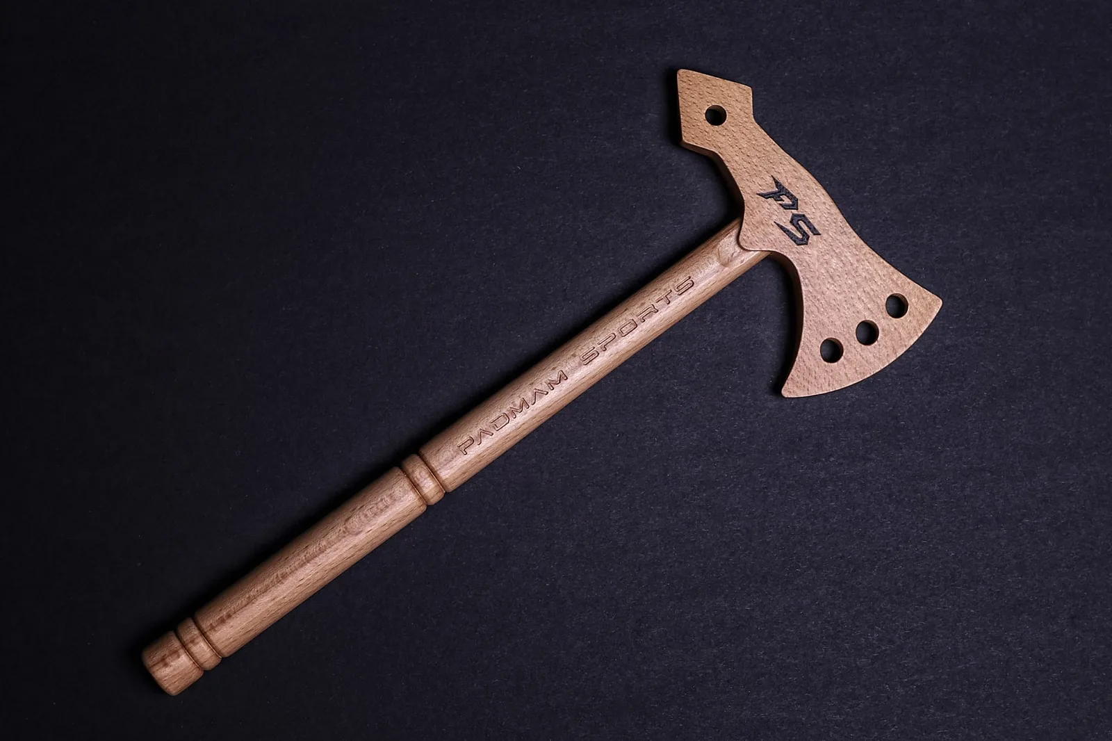 Trainings-Tomahawk aus Edelholz Esche mit PADMAM-Branding auf schwarzem Hintergrund