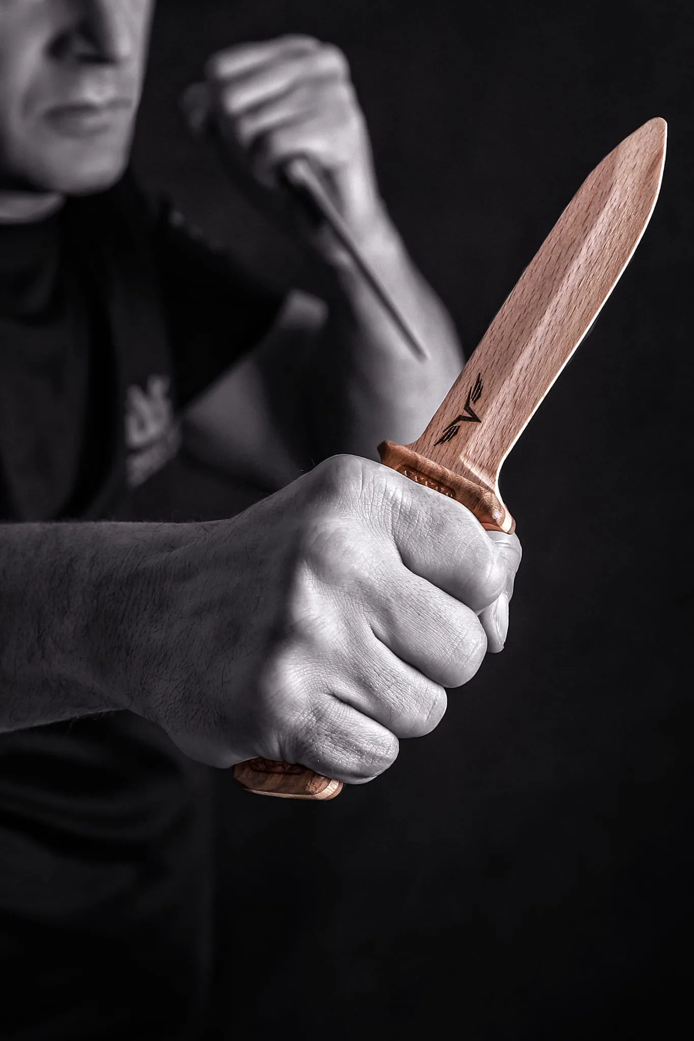 Hand hält Trainingsmesser aus hellem Edelholz mit PADMAM-Gravur