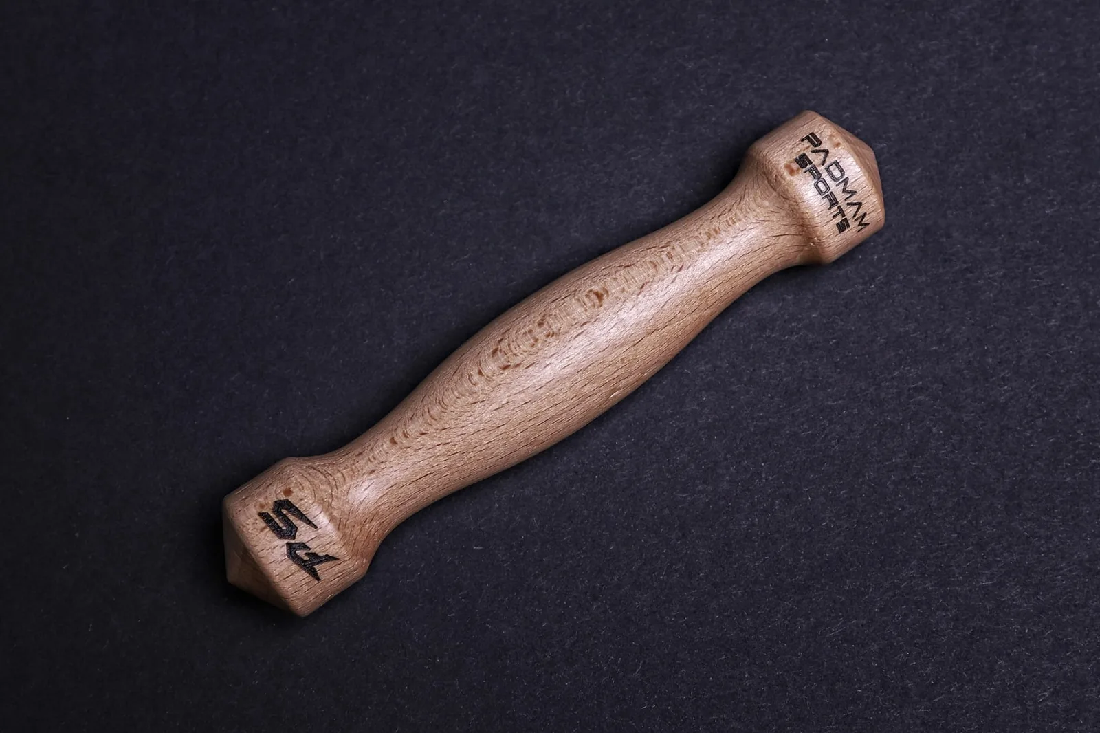 Holz-Yawara aus Buche mit PADMAM-Branding auf schwarzem Hintergrund