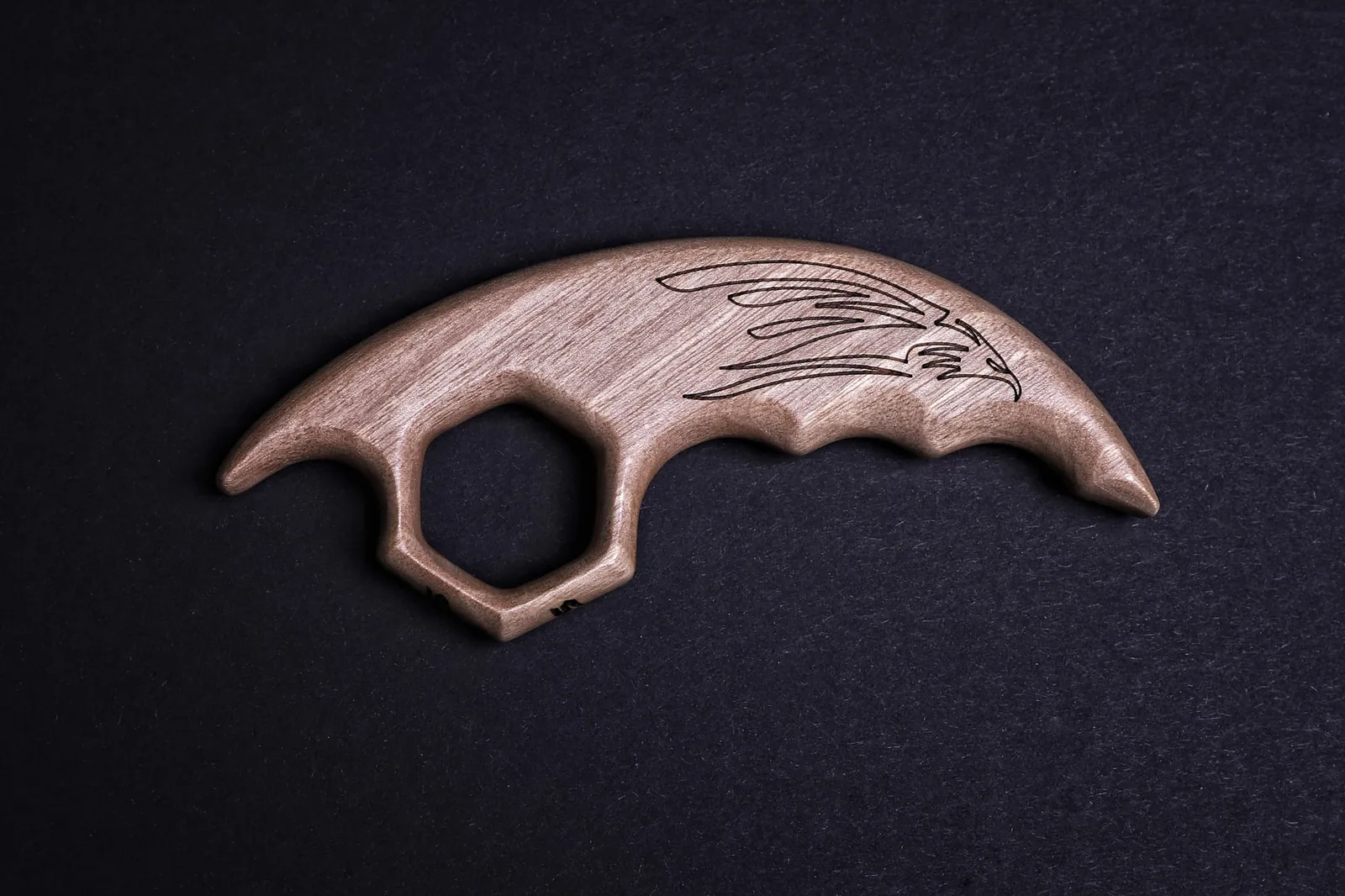 Holz-Karambit mit Eagle-Claw-Motiv auf schwarzem Hintergrund