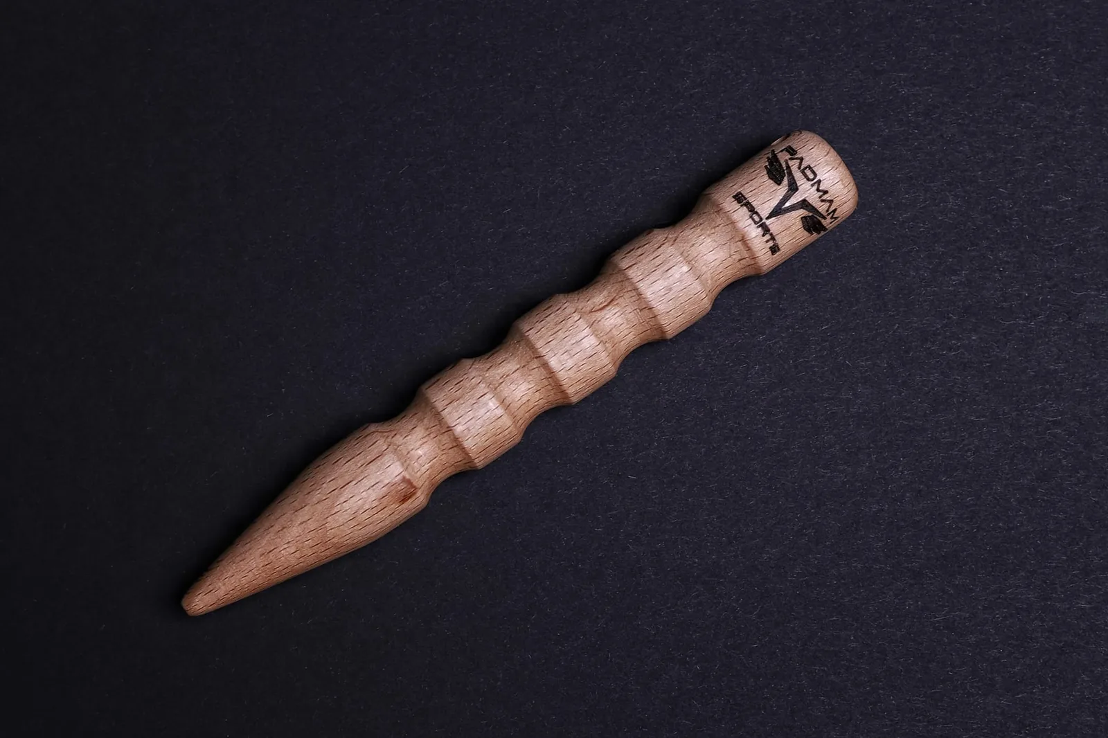Holz-Kubotan aus Buche mit PADMAM-Branding auf schwarzem Hintergrund