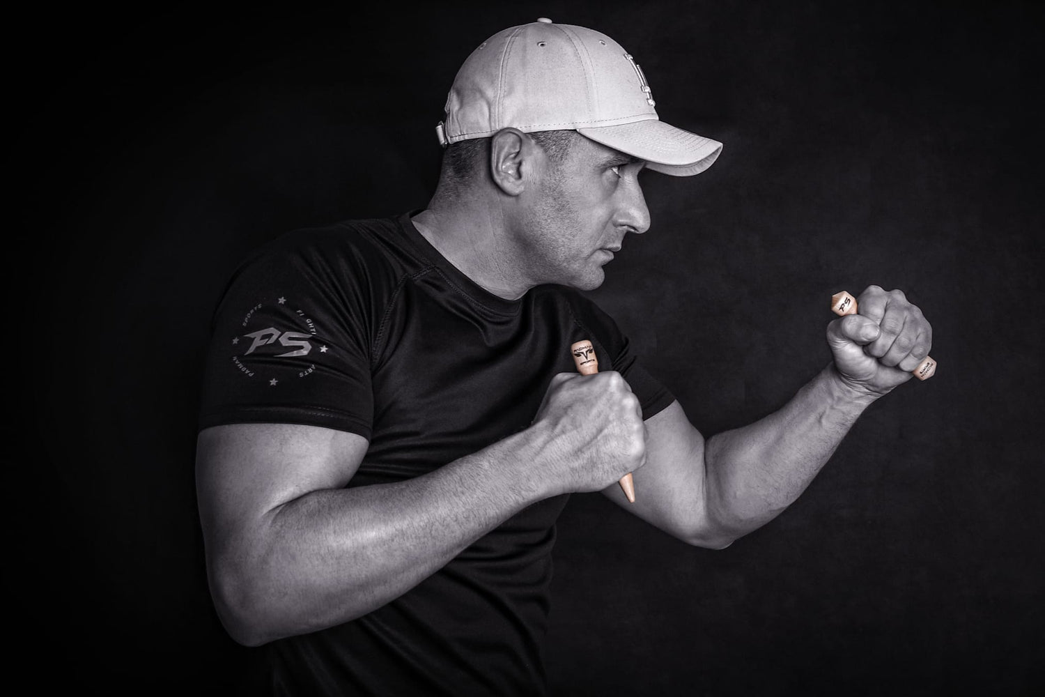 Mann mit weißer Kappe in Kampfposition hält Trainingspuppen, Protraitfoto