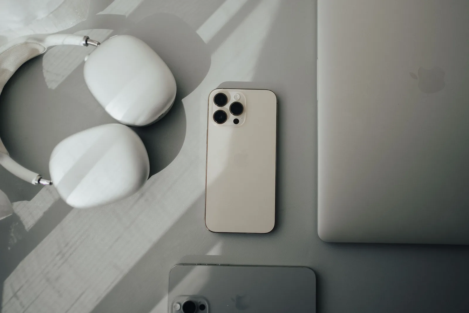 Flat-lay Produktfoto mit iPhone 13 Pro, Kopfhörern und Smartwatch auf minimalistischem weißem Hintergrund